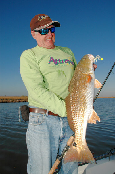 Howard Hammonds, president of Mystic Tackleworks, shows off a redfish he caught on an Attraxx Mystic Shrimp soft bait while fishing with Capt. Phil Robichauxs Guide Service and in the marshes near Lafitte, La.  (Photo by John N. Felsher)