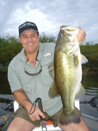 Billy chapman, Jr. shows off a bass he caught while fishing at Lake El Salto.