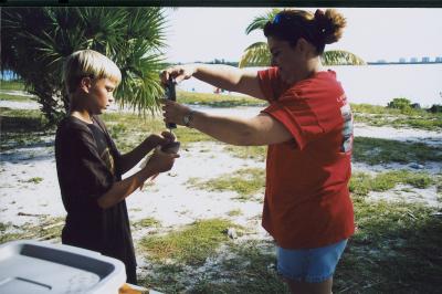 Junior Teen Angler volunteer - Tammy Ward weighing a fish for Justin Roe.