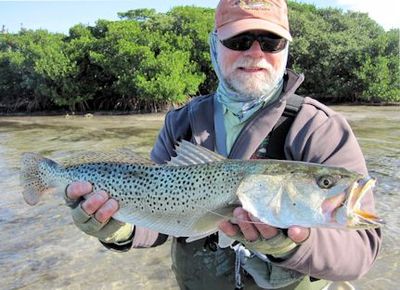 Capt. Rick Grassett with a big Sarasota Bay trout caught and released on a Grassett Flats Minnow fly while wading a sandbar.