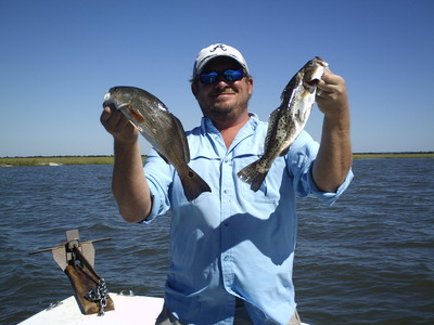 Captain Moody holds a River Red and a Sea Trout.