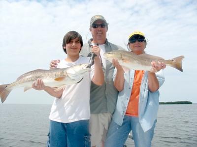 Steve Taylor and family with two hefty red fish