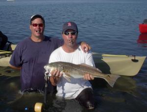 John Jones of Orlando, right, shows off a hefty Sarasota Bay redfish while his friend, Scott Connor of Sarasota, looks on.