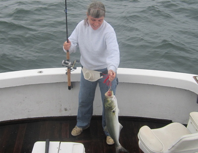 Annewith a big bluefish using a light action jigging outfit.