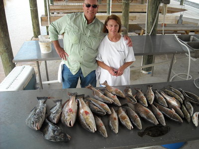 Joe Hiomel and joan Peterson with a limit od redfsih alond with some drum,trout and flounder